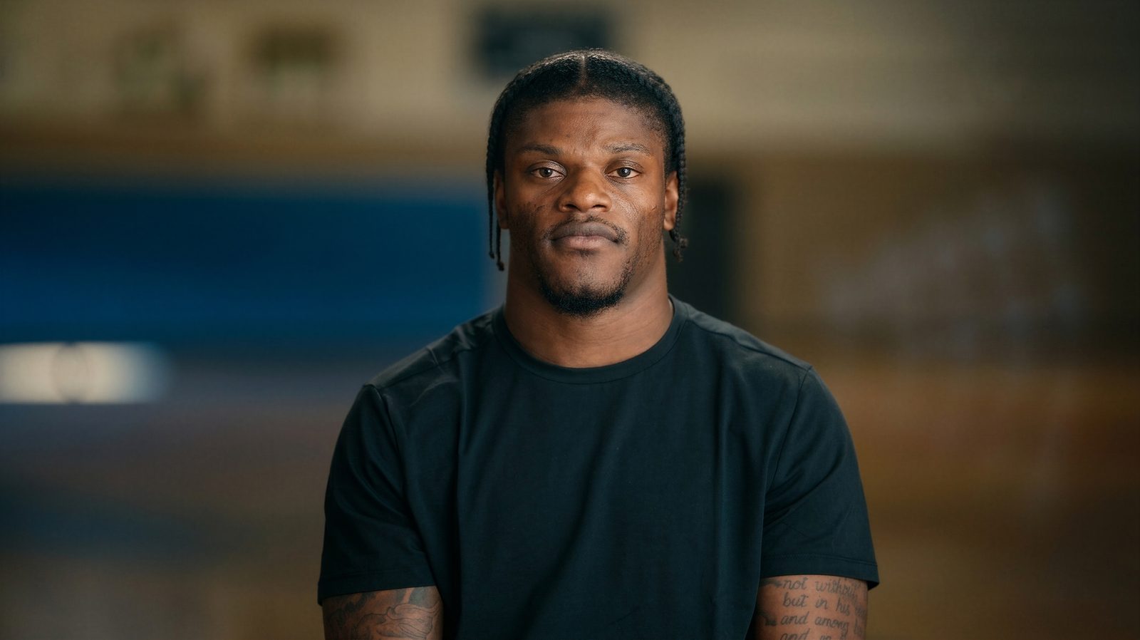 Lamar Jackson, focused and looking directly into camera in a training gym.